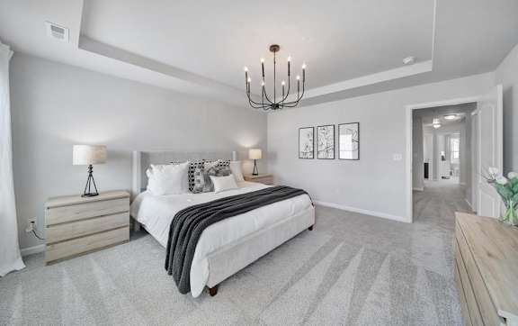 A bedroom with a large bed and a chandelier.