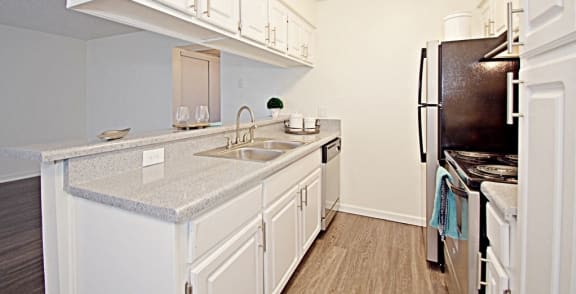 a kitchen with white cabinets and a sink and a refrigerator