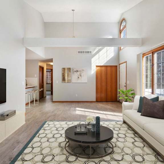 A living room with a white couch and a black coffee table.