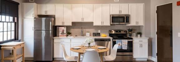 A kitchen area with a table and chairs.