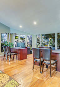 a dining room with a table and chairs and a living room with windows