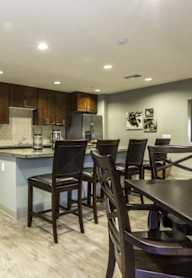 A kitchen with a white refrigerator and a stainless steel sink.