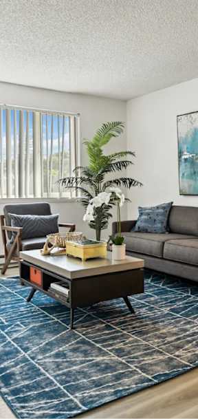 A living room with a grey couch, a coffee table, and a painting on the wall at Bridge City, Portland, 97236