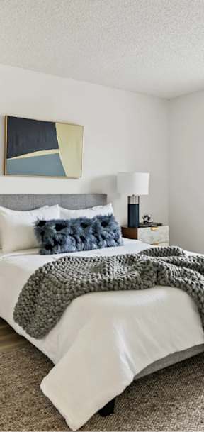 A bedroom with a large bed and a painting on the wall at Bridge City, Portland Oregon