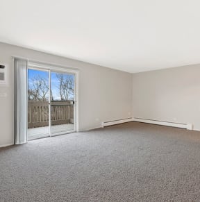 an empty living room with a door to a balcony