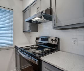 kitchen with white cabinets and a black stove top oven at THE EASTWOOD, AUSTIN, TX 78705