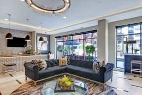 The front office and resident lounge with couches, a TV, and a coffee table at Gatsby Apartments. 