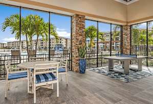 A balcony with a table and chairs overlooking a body of water.