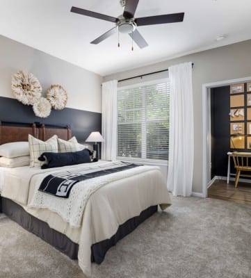 a bedroom with a bed and a ceiling fan
