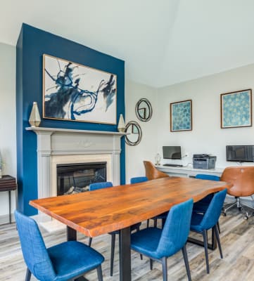 clubhouse interior with a table and chairs in front of a fireplace