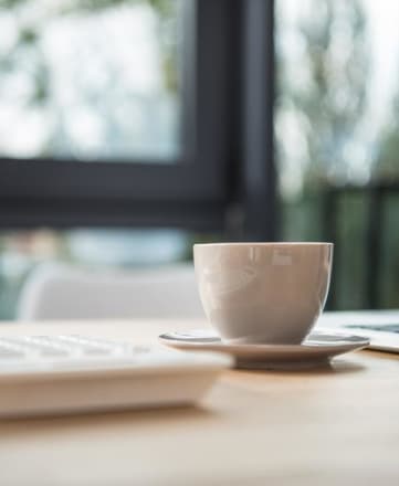 Coffee cup next to laptop The Meridian at Lakewood, Lakewood, CO, 80228