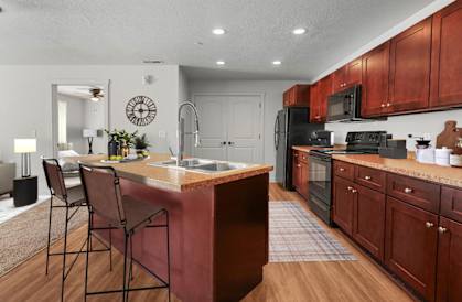 A kitchen with a brown island and brown cabinets.