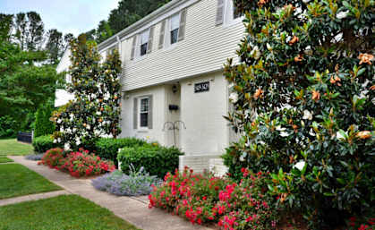 a white house with a garden in front of it at Midtown Park Townhomes, Raleigh, 27609