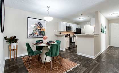 an open kitchen and dining area with a table and chairs at Indigo Apartments Gainesville, Gainesville, GA