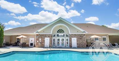 A house with a pool in front of it.