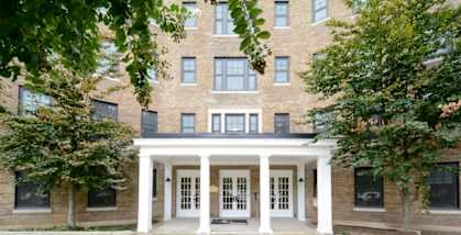 a large brick building with white pillars in front of it