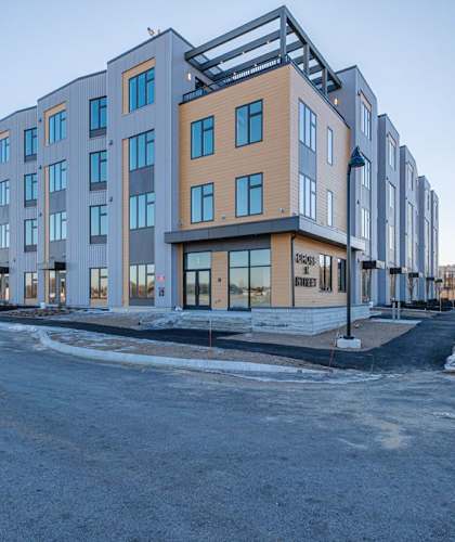 A modern multi-story residential building with a flat roof and balconies.