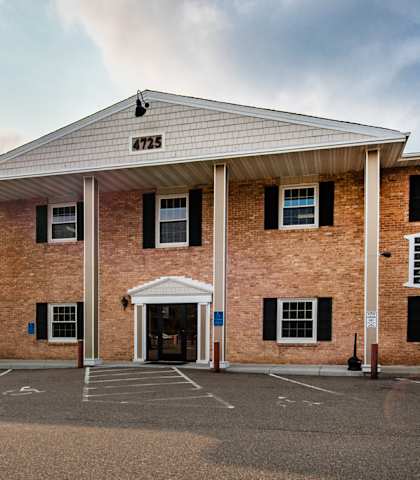 the front of a brick building with a porch