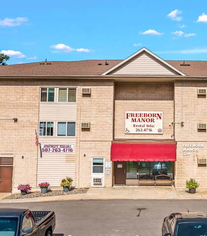 A building with a red awning and a sign that says Freeborn Manor.