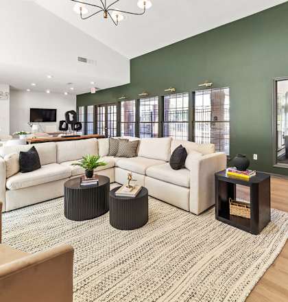 A living room with a white couch, a coffee table, and a rug.