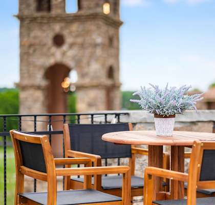 a table with a vase of flowers on a balcony