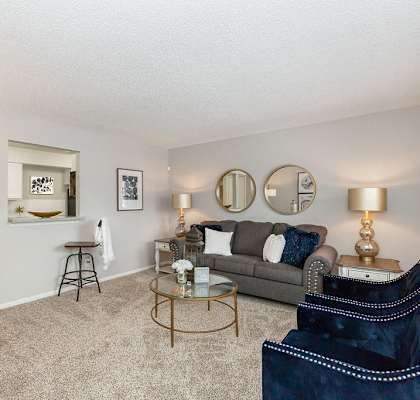 Kitchen with Breakfast Bar Opening Up to Carpeted Living Room