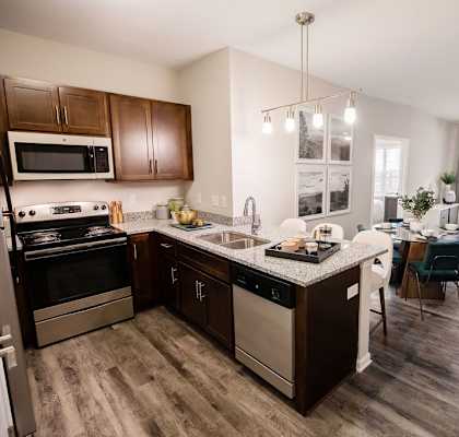 A kitchen with dark wood cabinets and a black stove top oven.
