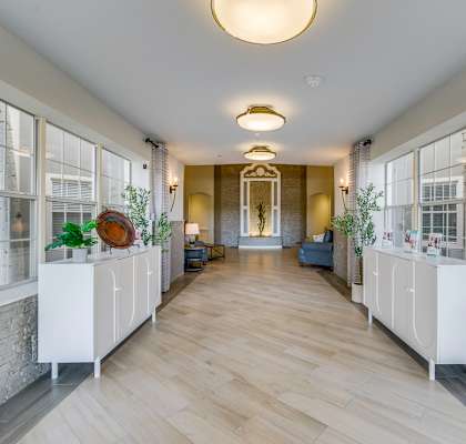 A long hallway with white cabinets on either side and a light hanging from the ceiling.