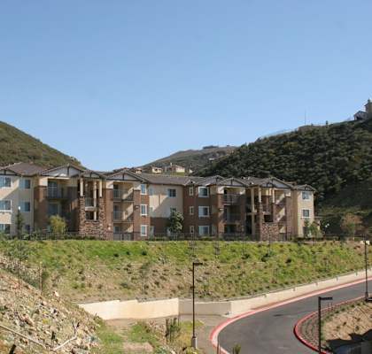 a group of apartment buildings on a hillside with a road