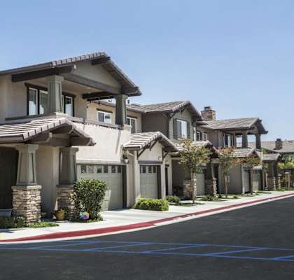 a row of houses on a street with a parking lot