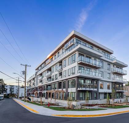 A modern multi-story building with balconies and large windows.
