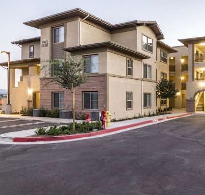A large apartment complex with a red fire hydrant in front.