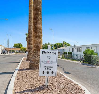 a sign in front of a palm tree at Aloha Vegas in North Las Vegas