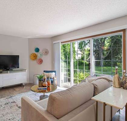 a living room with a couch and a tv at Seasons Villas, Woodbury, MN