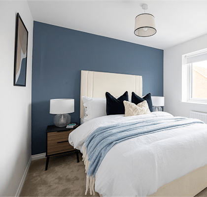 A bedroom with a white bed and a blue blanket.