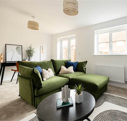 A living room with a green couch and a coffee table.