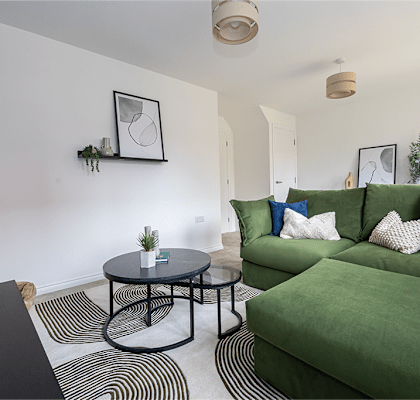 A living room with a green couch and a black table.