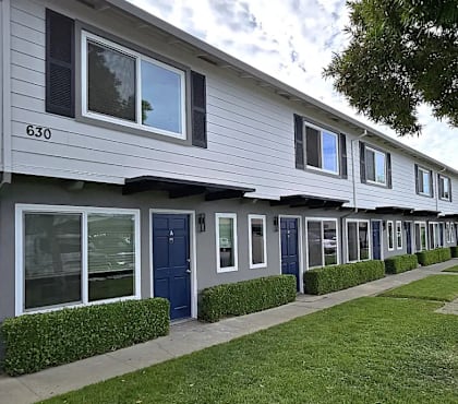 A row of houses with blue doors and windows.