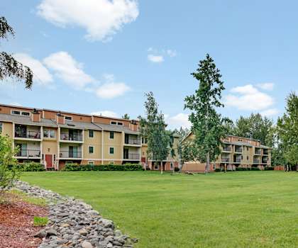 Apartment complex with a green lawn in front.