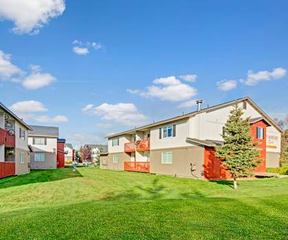 A row of houses with green lawns in front.