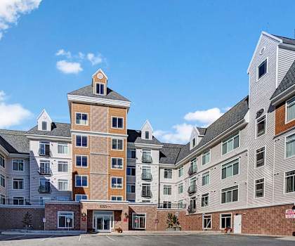 The front entrance to the apartment buildings with uncovered parking, potted plants, and at Park Plaza II. 