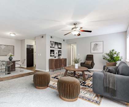 A living room with a grey couch, a wooden coffee table, and a ceiling fan.