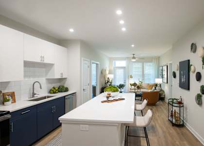 a kitchen and living room with a white counter top
