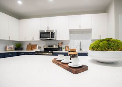 a white kitchen with white counters and a white counter top