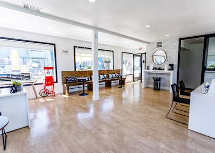 A spacious office with wooden floors and white furniture.