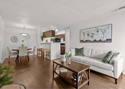 A living room with a white couch and a wooden coffee table.