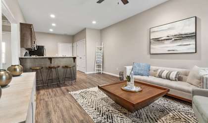 A living room with a brown coffee table and a painting on the wall.