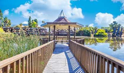 a wooden bridge leading to a gazebo on the water