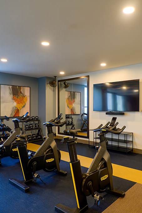 a gym with cardio equipment and mirrors in a building