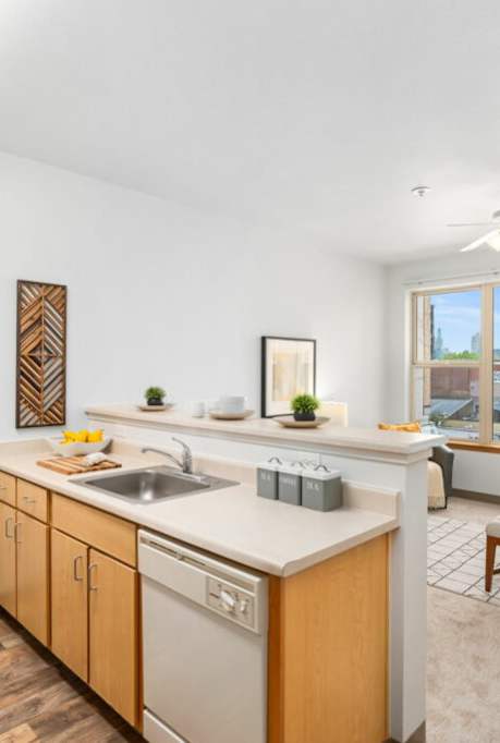 A kitchen with wooden cabinets and a white countertop.at Fifth Avenue Place Apartments, Portland